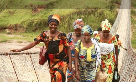 People from rewanda walking across bridge