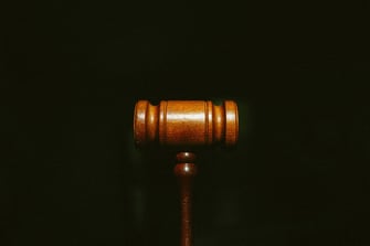 A wooden gavel on a dark background.