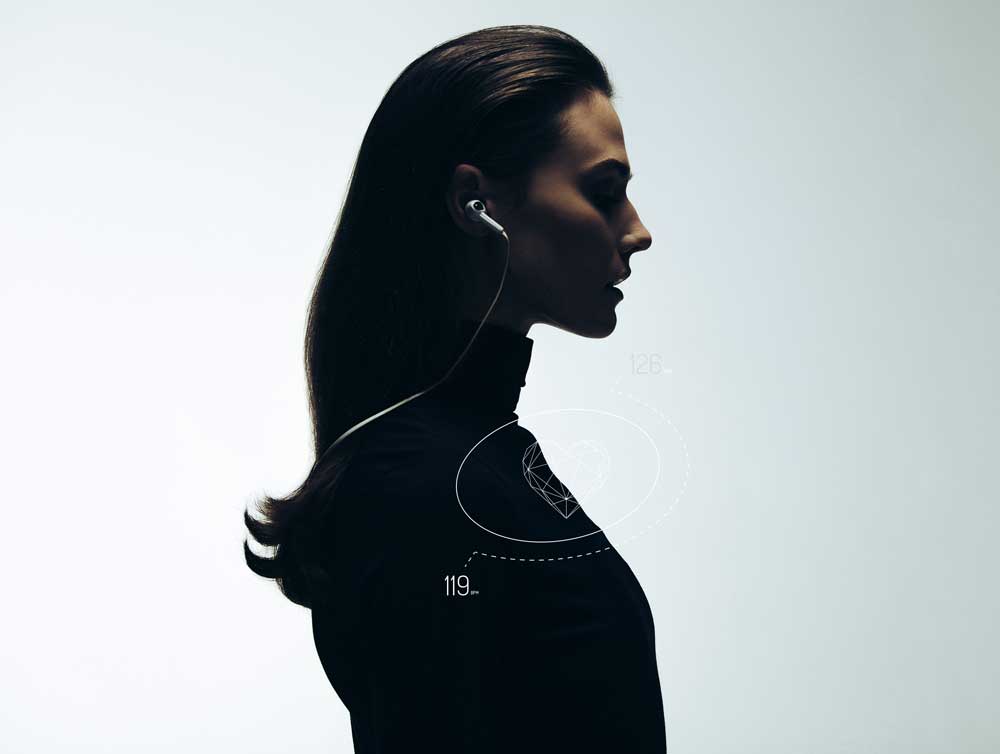 The silhouette of a woman with long hair, wearing earphones.