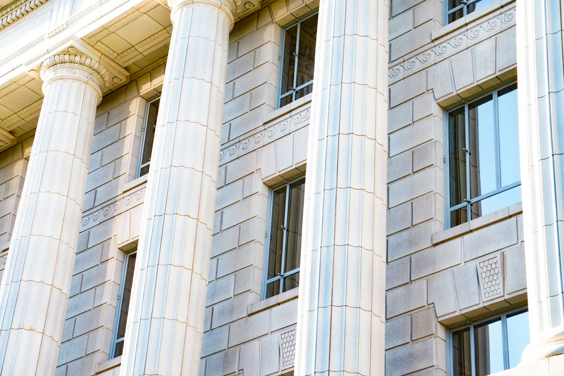 A section of a building with a classical architectural style, featuring a series of tall, slender columns with decorative capitals.
