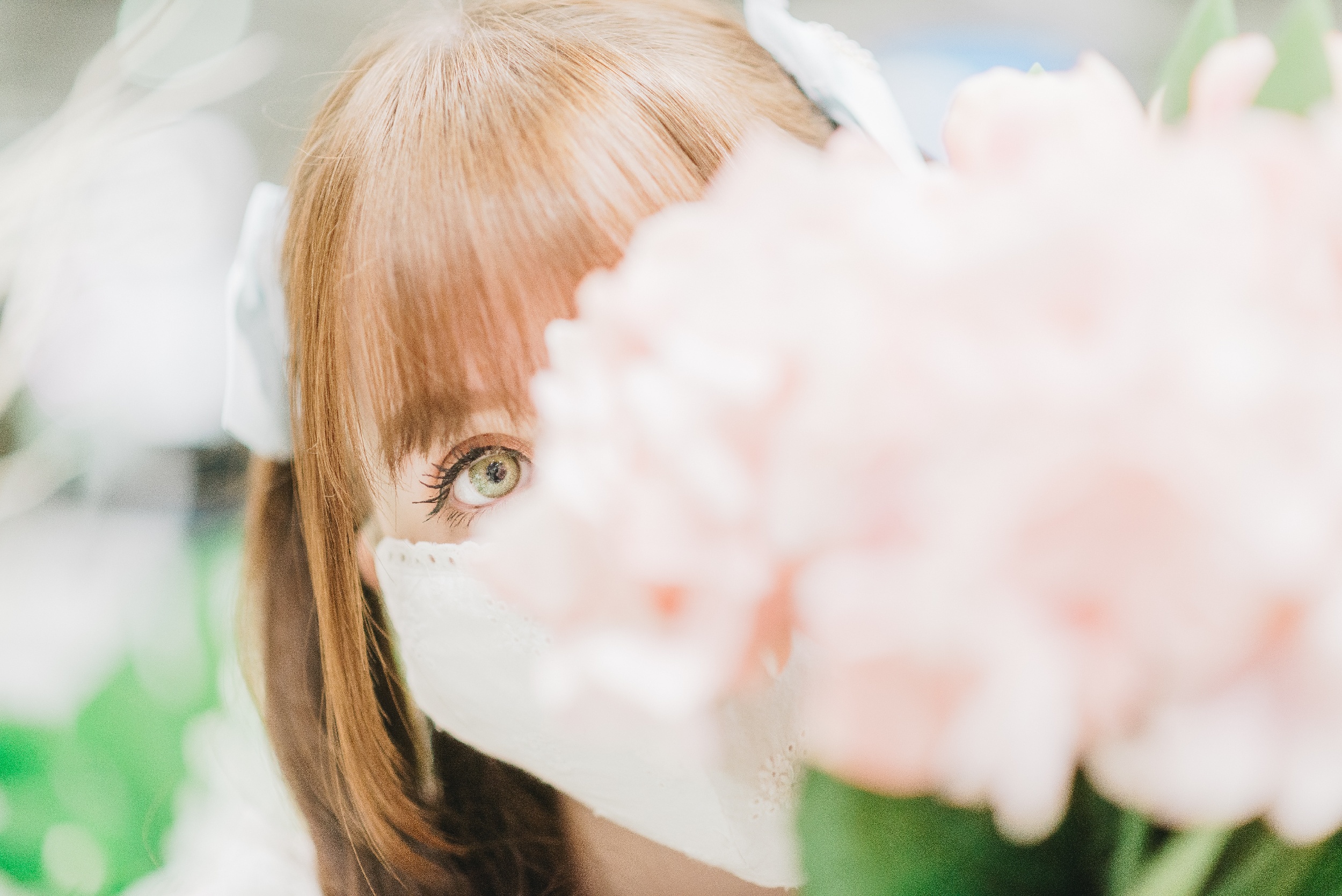 woman with a mask peeking around a pink flower